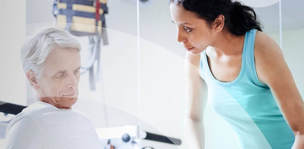 Physiotherapist helping elderly male